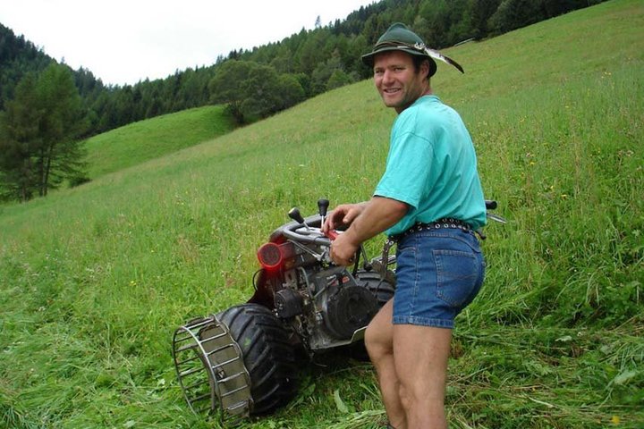 Bauer Christian mäht das Gras für die Kühe.